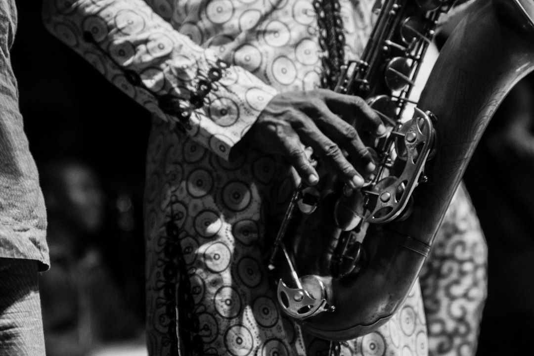 Zwart-wit close-up van een musicus die saxofoon speelt